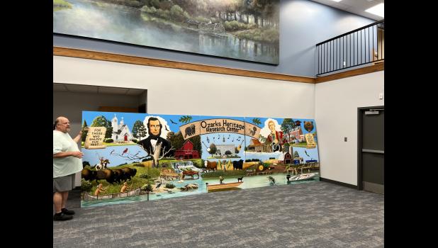 Artist Paul Jones, Mountain View, presents his mural of the past, present and future of the Ozarks to officials at the Ozarks Heritage Research Center in West Plains. The mural will be dedicated at 5:15 p.m. Dec. 3 at the center. photo provided