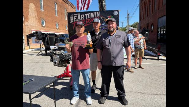 Winner of the Sparkplug Shootout Terry Phelps, left, with John Bailey of Bailey Chevrolet, and Lance Wittkofski, right, contest judge photo provided