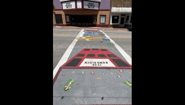 A new crosswalk mural painted by Ricky Baker tells the story of 1926 plane crash. Howell County News/Grace Long
