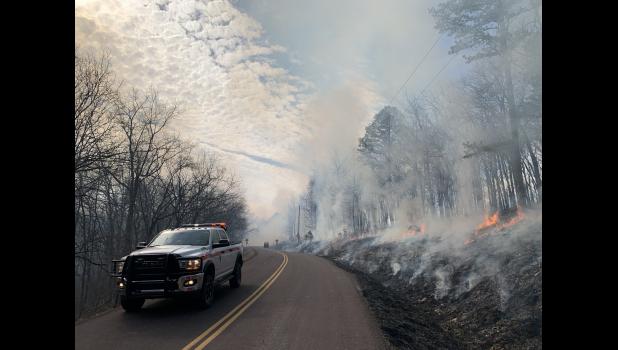 Firefighters carefully monitor a prescribed burn along a state highway. photo courtesy of the NPS
