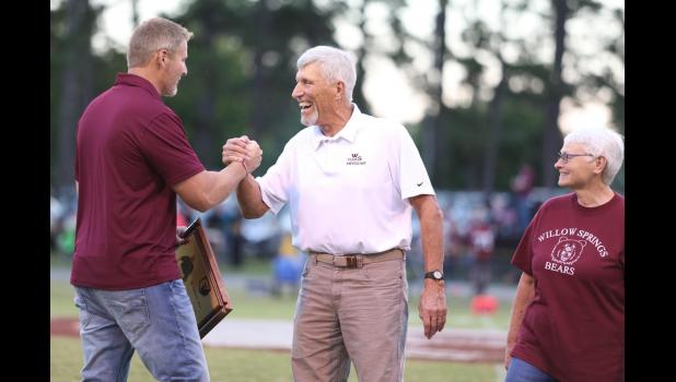 With his wife Janet at his side, Dr. Bob Shaw (center) accepts a plaque from Athletic Director Robert James Friday night. courtesy of Shawana Cox