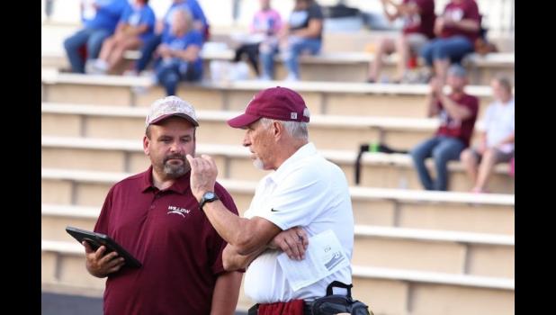 Dr. Shaw throughout the years: conversing with Coach David Cox and treating an injured player on Palenske Field. Shaw volunteered his services as team physician for forty years. courtesy of Shawana Cox